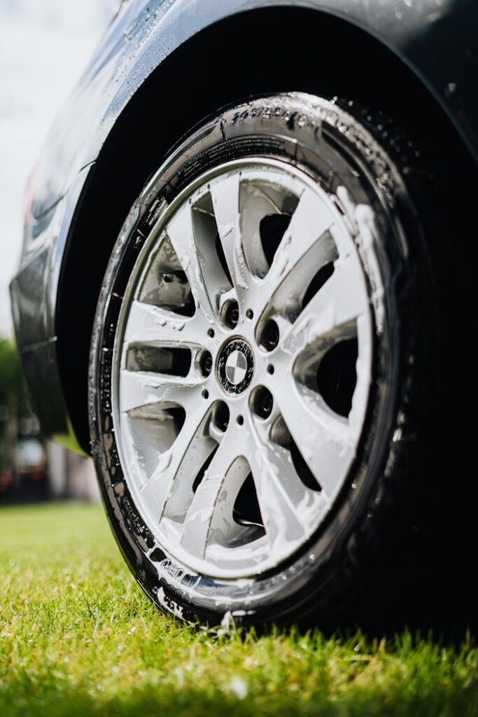 Mastering the First Impression: Your intriguing post title goes here A detailed view of a car wheel being cleaned with soap on a sunny day.